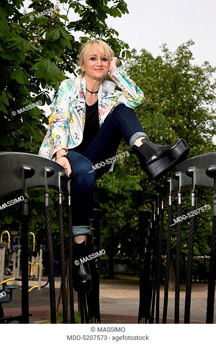 Actress and comedian Luciana Littizzetto sitting in a playground inside the public park Parco del Valentino. Turin, Italy. 21st April 2016