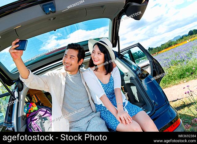 Young couple sat in the car trunk