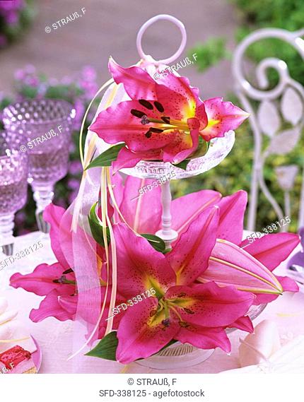 Lilies on tiered stand with ribbons