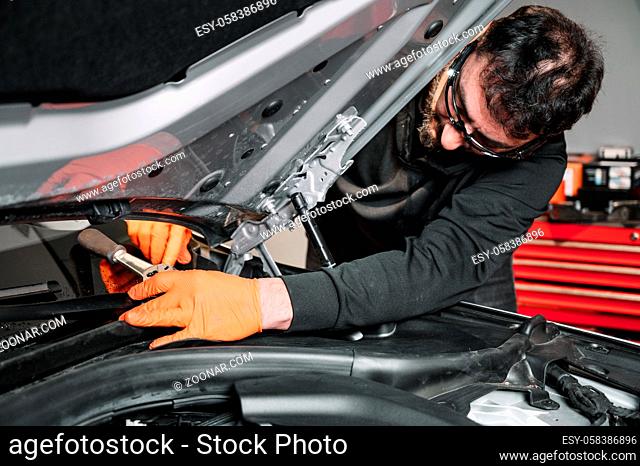 Auto mechanic working and repair on car engine in mechanics garage. Car service. High quality photo