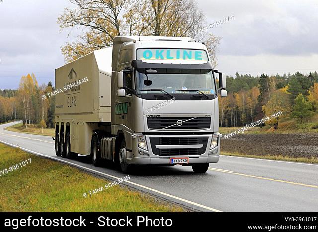 Silver Volvo FH truck of Okline Oy pulls Saint-Gobain glass trailer along rural highway on a day of autumn. Salo, Finland. October 11, 2019