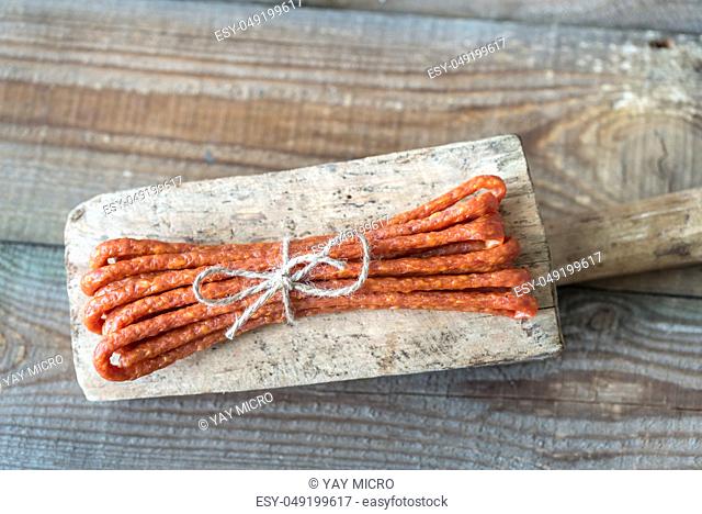 Smoked sausages on the wooden background