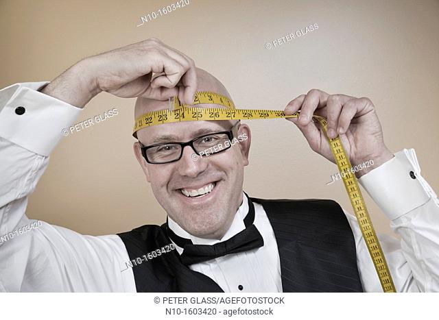 Middle-age bald man measuring his head