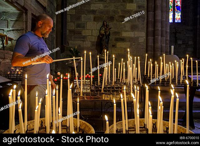 Man lighting a votive candle, devotional candles, Notre Dame Church, Saint-Jean-Pied-de-Port, Camino de Santiago, Via Podiensis, Camino Francés, Pyrenees