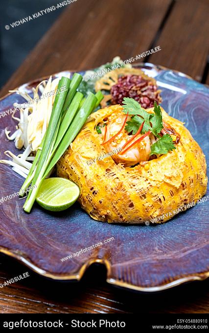 Padthai, Thai style pan fried rice noodle with tamarind sauce, serve with grilled tiger prawn cover with omelette. Thai gourmet cuisine recipe Restaurant...