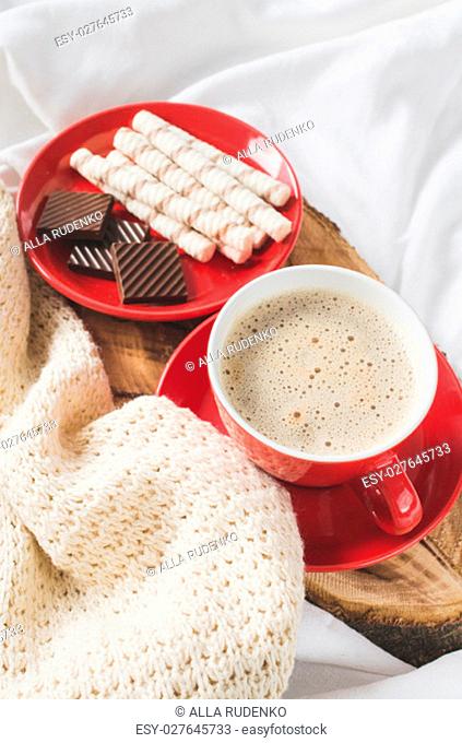 Breakfast in Bed. Tray with Cappuccino and Chocolate on a Bed with Plaid in Bedroom Interior. Selective Focus
