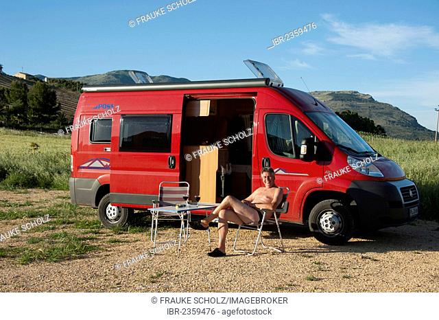 Man sitting in front of a campervan, Segesta, Province Trapani, Sicily, Italy, Europe