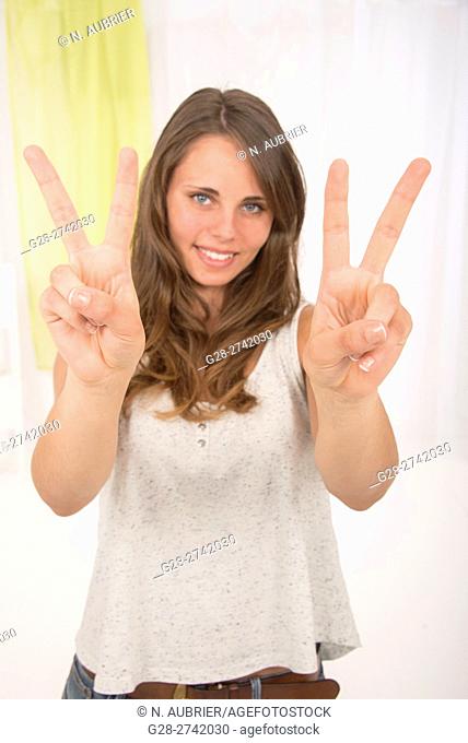 Young woman making the V of victory with her fingers to express her happiness and her success