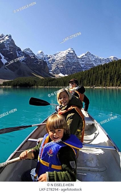 Family in paddle boat, Moraine Lake, Banff National Park, Alberta, Canada