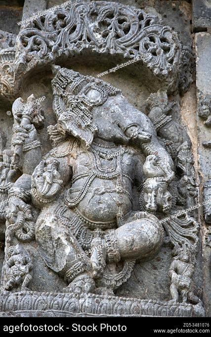 Carved Ganesha standing idol on the outer wall of Kedareshwara Temple, Halebidu, Karnataka, India