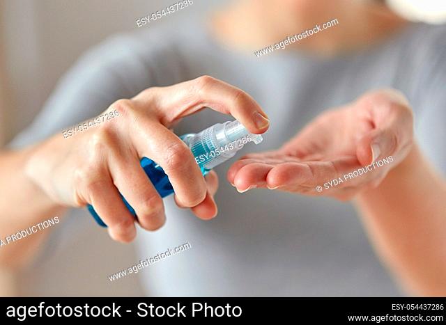 close up of woman spraying hand sanitizer