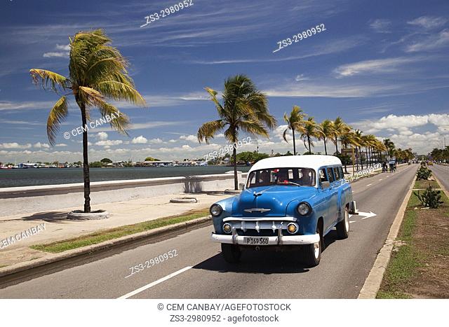Old American car by the water promenade Malecon at Punta Gorda district, Cienfuegos, Cuba, West Indies, Central America