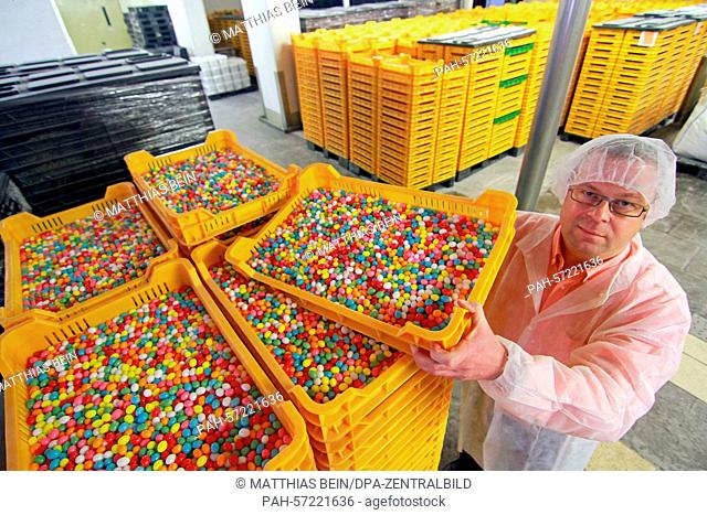 Dirk Thielemann examines a trough with sugar-coated eggs made by the company Bodeta Suesswaren GmbH in Oschersleben, Germany, 23 March 2015