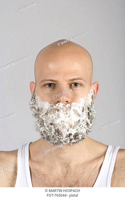 A man with shaving cream all over his beard