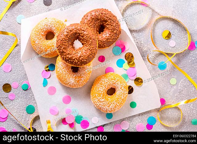 Donuts for carnival and party. Donuts with streamers and confetti. Colorful carnival or birthday image