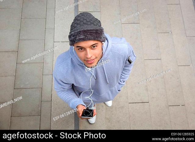 Listening to music young latin man runner sports training from above top view outdoor