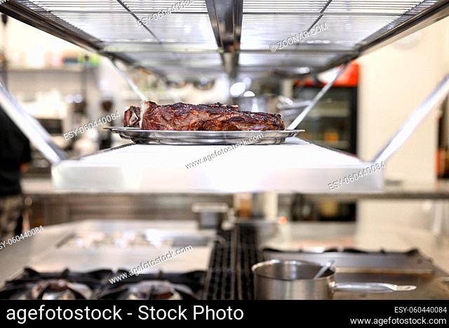 Commercial kitchen background. Plate of grilled meat ready to serve . High quality photo