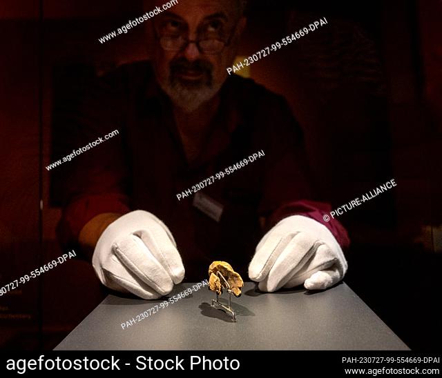 27 July 2023, Baden-Württemberg, Blaubeuren: An employee presents an ivory sculpture in the Museum of Prehistory. Archaeologists from the University of Tübingen...
