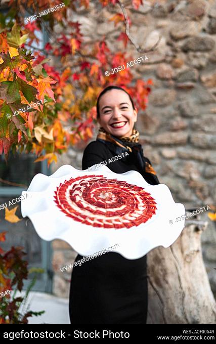 Happy chef holding red meat in flower shape plate