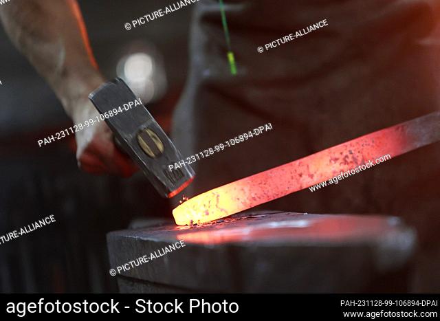 28 November 2023, Saxony-Anhalt, Wernigerode: Michele, an apprentice at the Harz smithy, makes a Celtic sword. The object is a copy of a more than 1000-year-old...