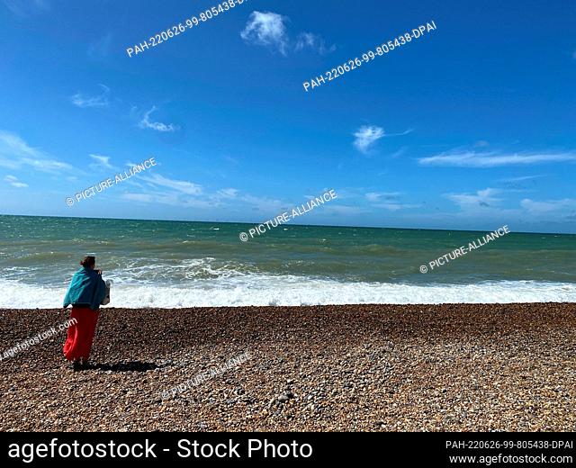 26 June 2022, Great Britain, Brighton: A woman takes a photo of the sea. Photo: Benedikt von Imhoff/dpa. - Brighton/East Sussex/Great Britain