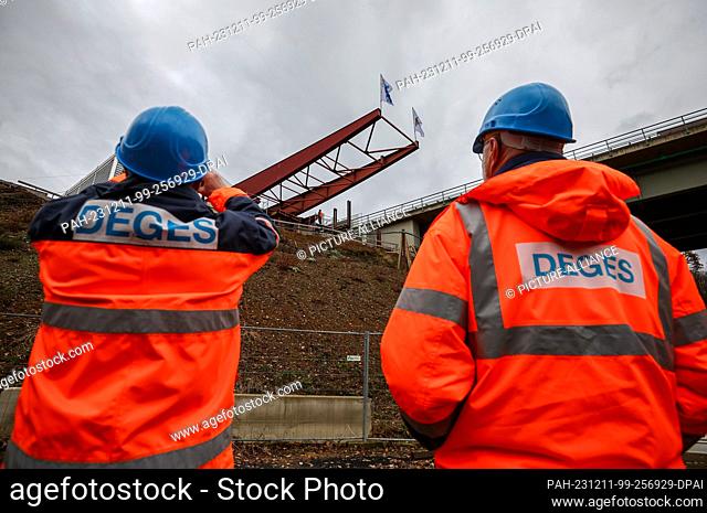 11 December 2023, Saxony, Grimma: Two DEGES employees are following the movement of the stem fork during the incremental launching process of the new Mulde...
