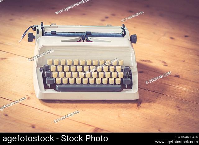 Vintage typewriter on a wooden desk, cutout