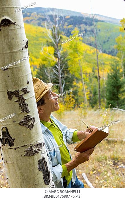 Man reading book in autumn forest