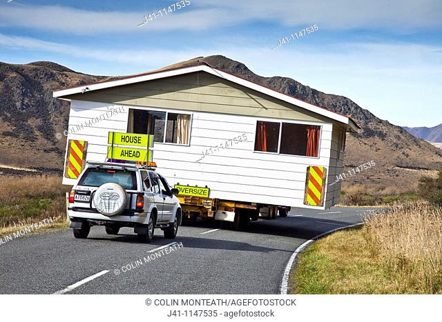 House being relocated by truck and escort vehicles, Mt. Somers, Canterbury, New Zealand