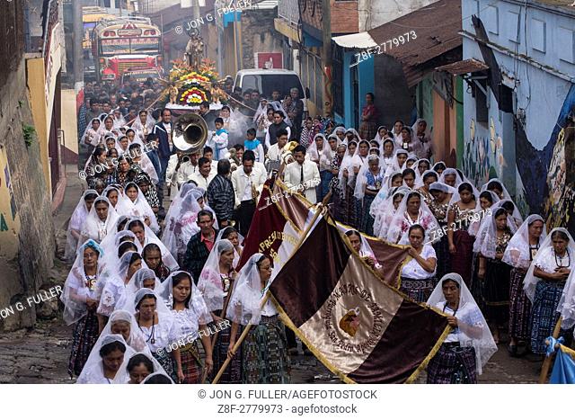 Catholic procession of the Virgin of Carmen in San Pedro la Laguna, Guatemala. Women in traditional Mayan dress with white mantillas over their heads