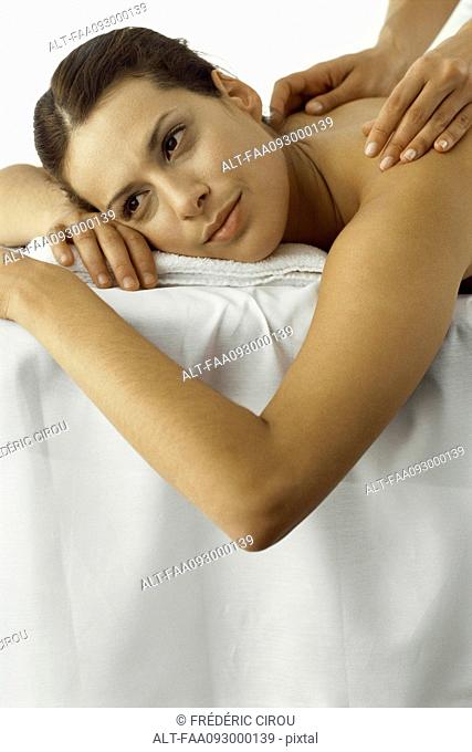 Woman receiving back massage, smiling, close-up