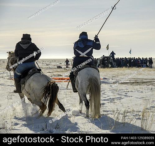 Two locals on horseback arrive at the Soyuz MS-13 spacecraft shortly after it landed in a remote area near the town of Zhezkazgan