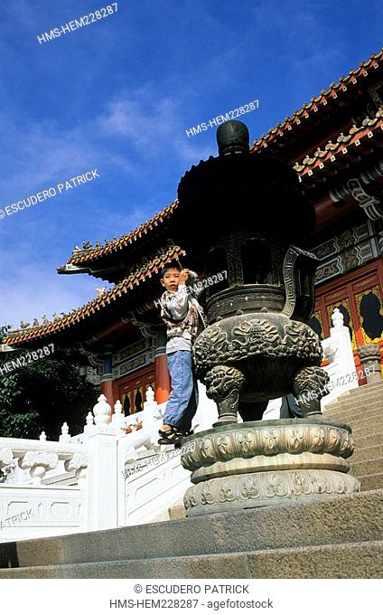China, Hong Kong, Lantau Island, Po Lin Monastery, child on an censer in front of a Monastery