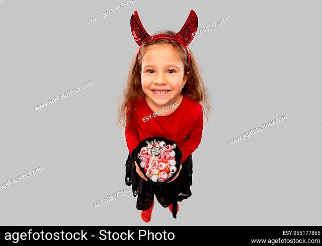 girl with horns trick-or-treating on halloween