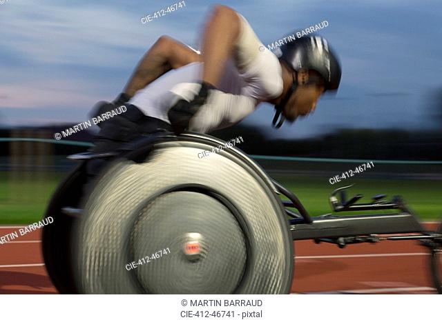 Paraplegic athlete speeding along sports track in wheelchair race