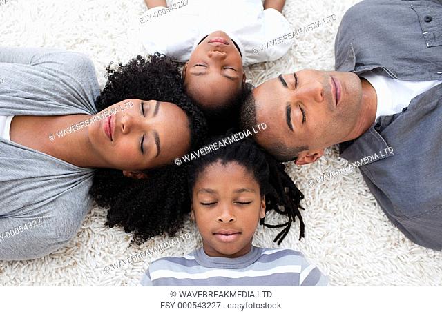 Afro-American young family lying on floor with their heads together