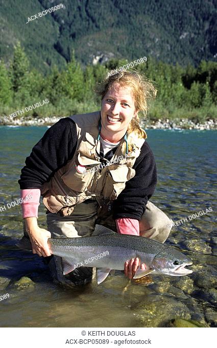 Lady angler holding steelhead, Dean river, British Columbia, Canada