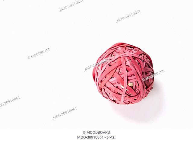 Close-up of rubber band ball over white background