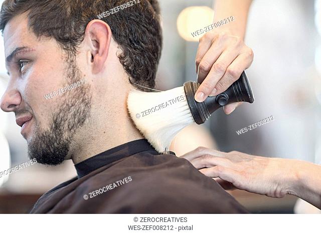Young man at barber's shop getting neck brushed