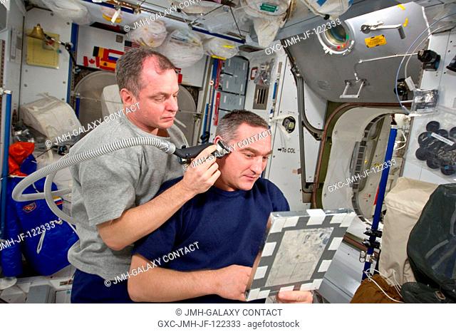 NASA astronaut T.J. Creamer, Expedition 23 flight engineer, trims Russian cosmonaut Alexander Skvortsov's hair in the Harmony node of the International Space...
