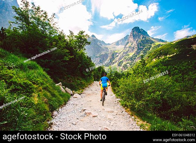 a cyclist riding in the high Tatras, Slovakia. girl on mountain bike in blue veloform