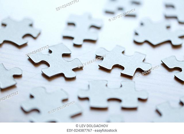 business and connection concept - close up of puzzle pieces on table