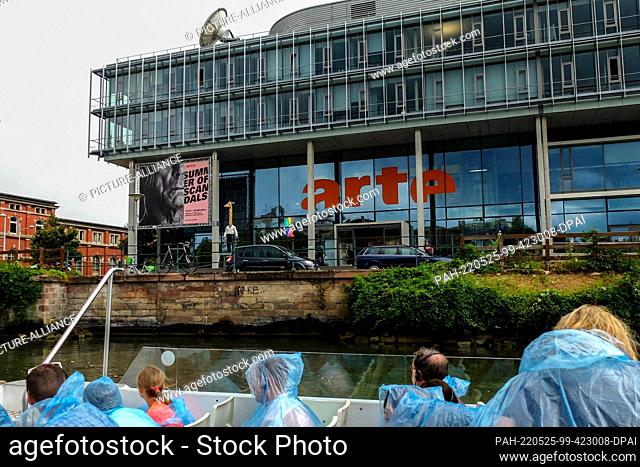 27 August 2016, France, Straßburg: Tourists pass the building of the Franco-German television station Arte during a boat trip on the Ill River