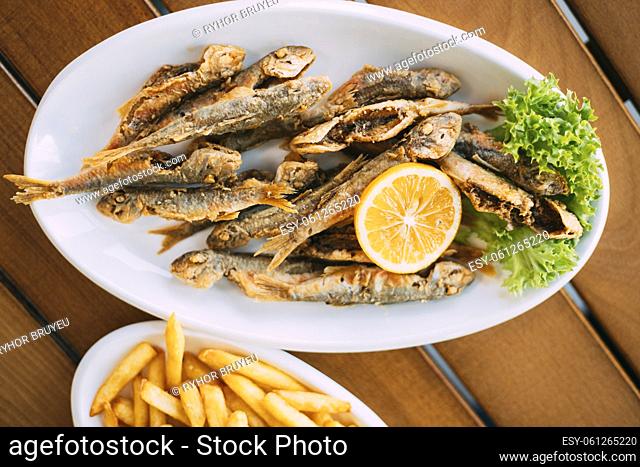 Dish Of Georgian National Cuisine: Mullet Fish With orange and french fries. fish and chips