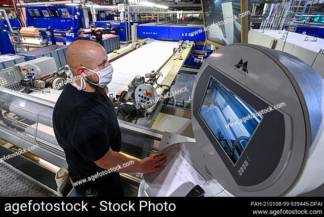 07 January 2021, Saxony, Niederfrohna: Danny Jost, stenter frame operator, monitors a textile machine in production at textile finisher pro4tex