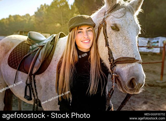 Portrait of woman with horse in paddock