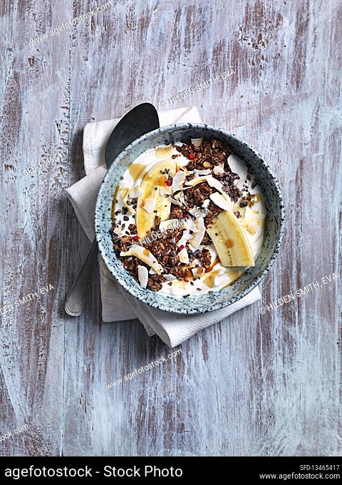 Bananan bowl with granola, honey, coconut flakes and yoghurt