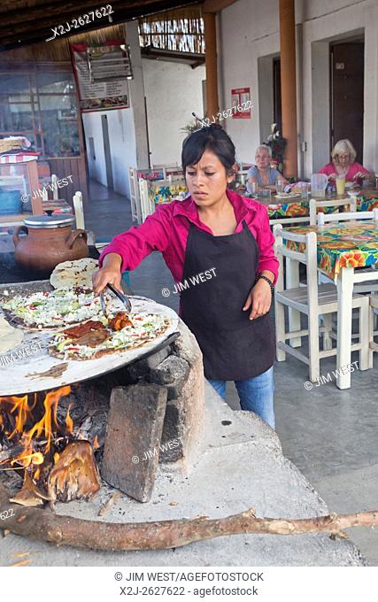 Santiago Matatlán, Oaxaca, Mexico - A worker makes tlayudas on a comal in a Oaxaca restaurant