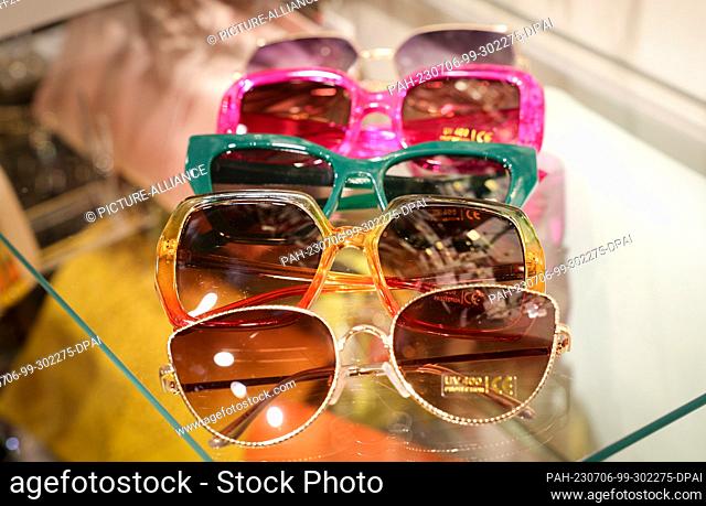PRODUCTION - 05 July 2023, Hamburg: Colorful and fancy sunglasses lie on the glass table of a fashion store. (to dpa Top or Flop? - Five fashion sins in the...