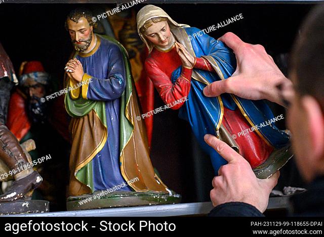 29 November 2023, Saxony-Anhalt, Hamersleben: Pastor Christoph Sperlin takes the Mother of God figure from a cupboard in the cloister of the former Hamersleben...